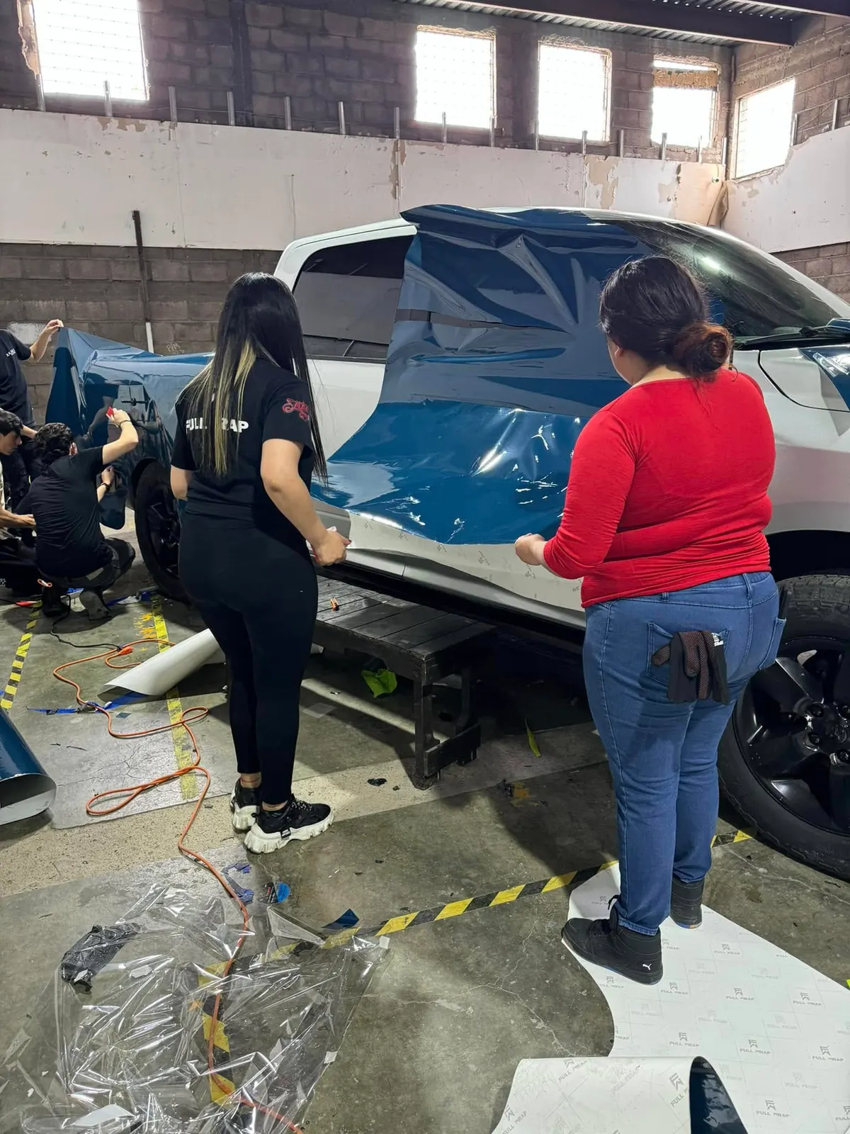 Alumnas instalando wrap en una camioneta durante el curso
