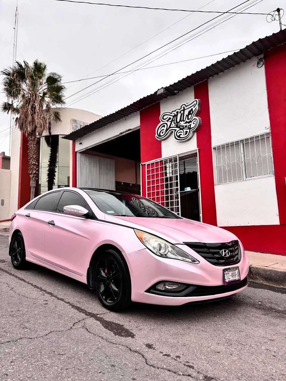 Hyundai Sonata con wrap rosa terminado por los alumnos del curso