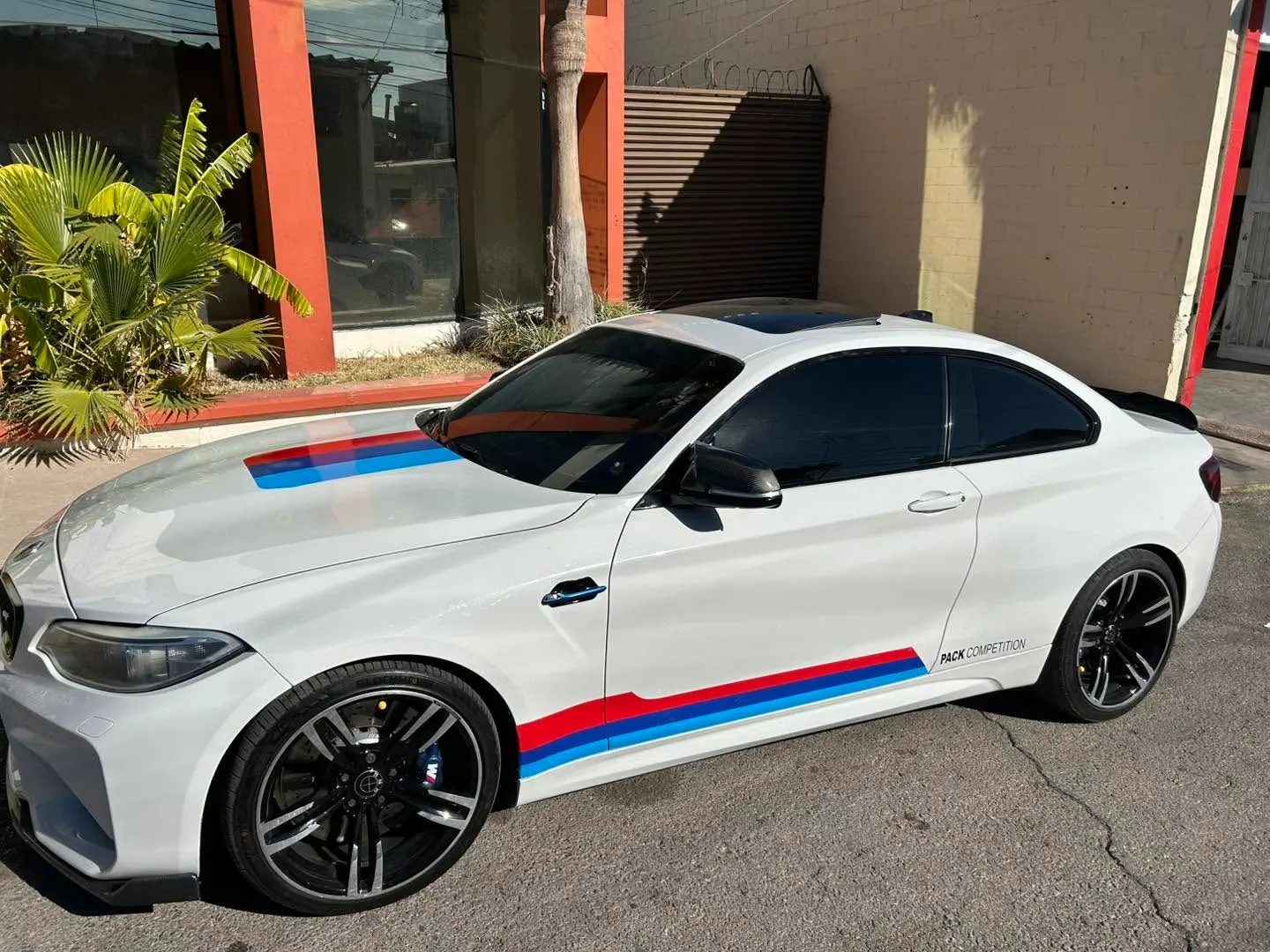 BMW blanco con franjas en los colores M