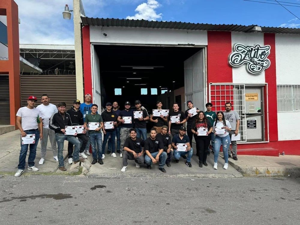 Grupo de egresados de la Escuela de Wrap con certificado, afuera del taller Auto Tuning Shop