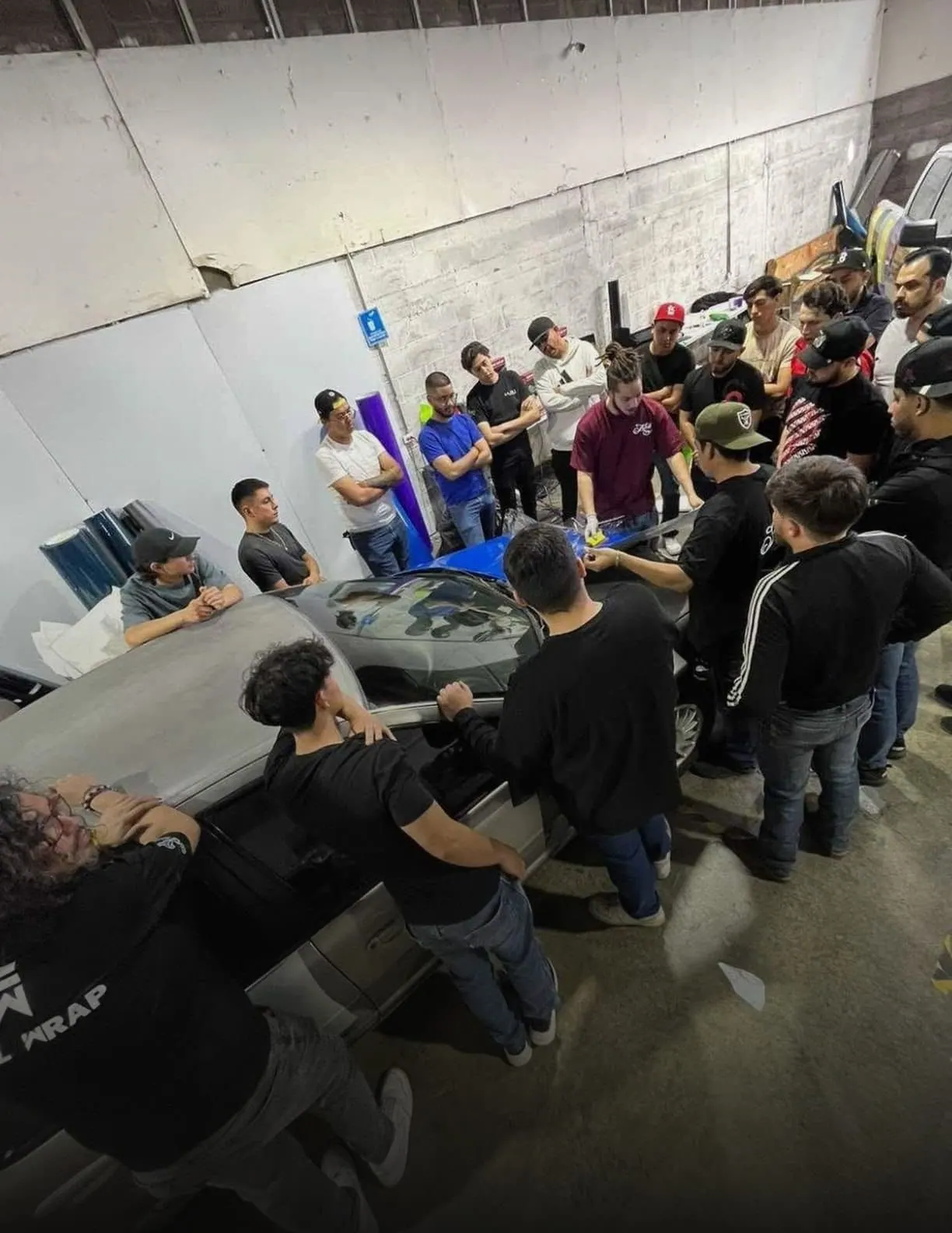 Grupo de alumnos aprendiendo instalación de wrap en el taller de Auto Tuning Shop
