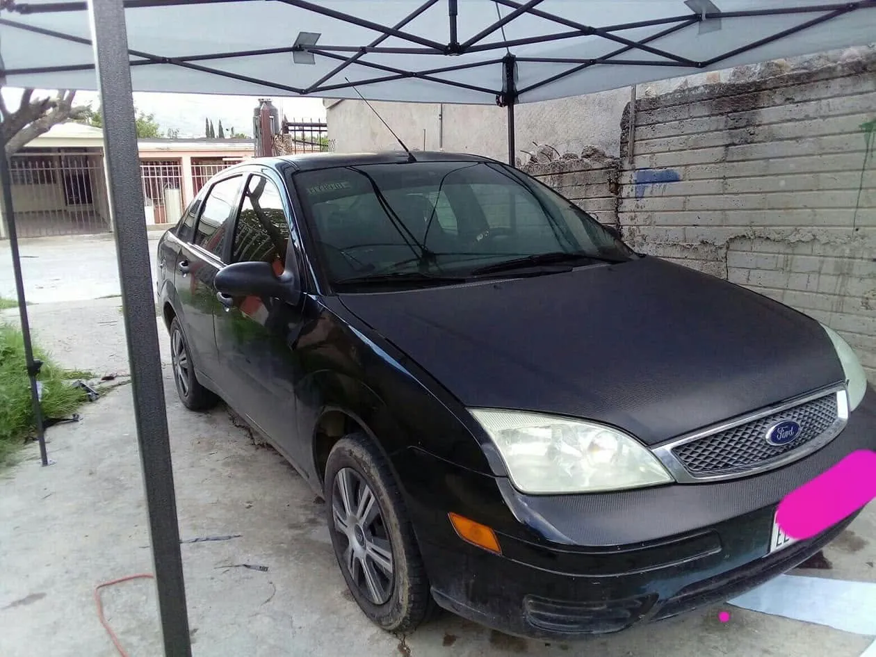 Ford Focus negro trabajado bajo la carpa en el patio