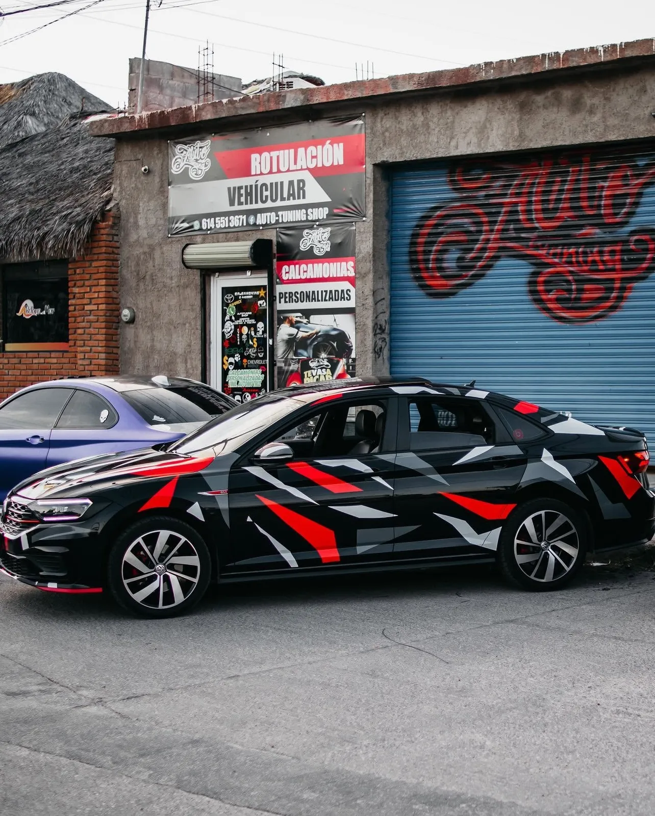 Volkswagen Jetta con wrap de camuflaje rojo, negro y blanco en el primer taller