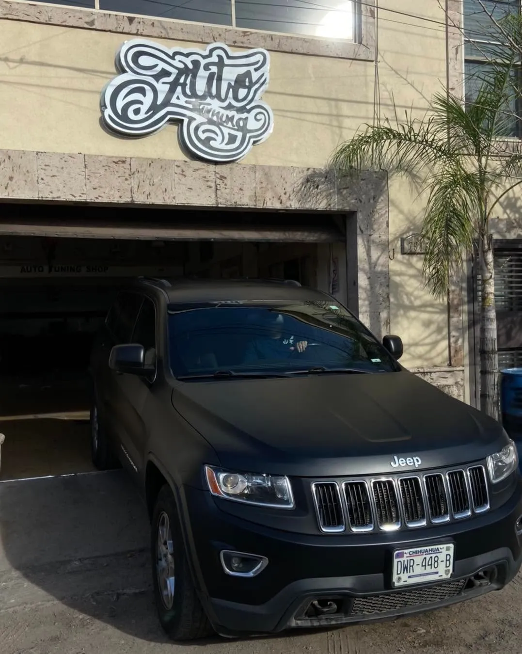 Jeep Grand Cherokee negro mate frente al segundo taller