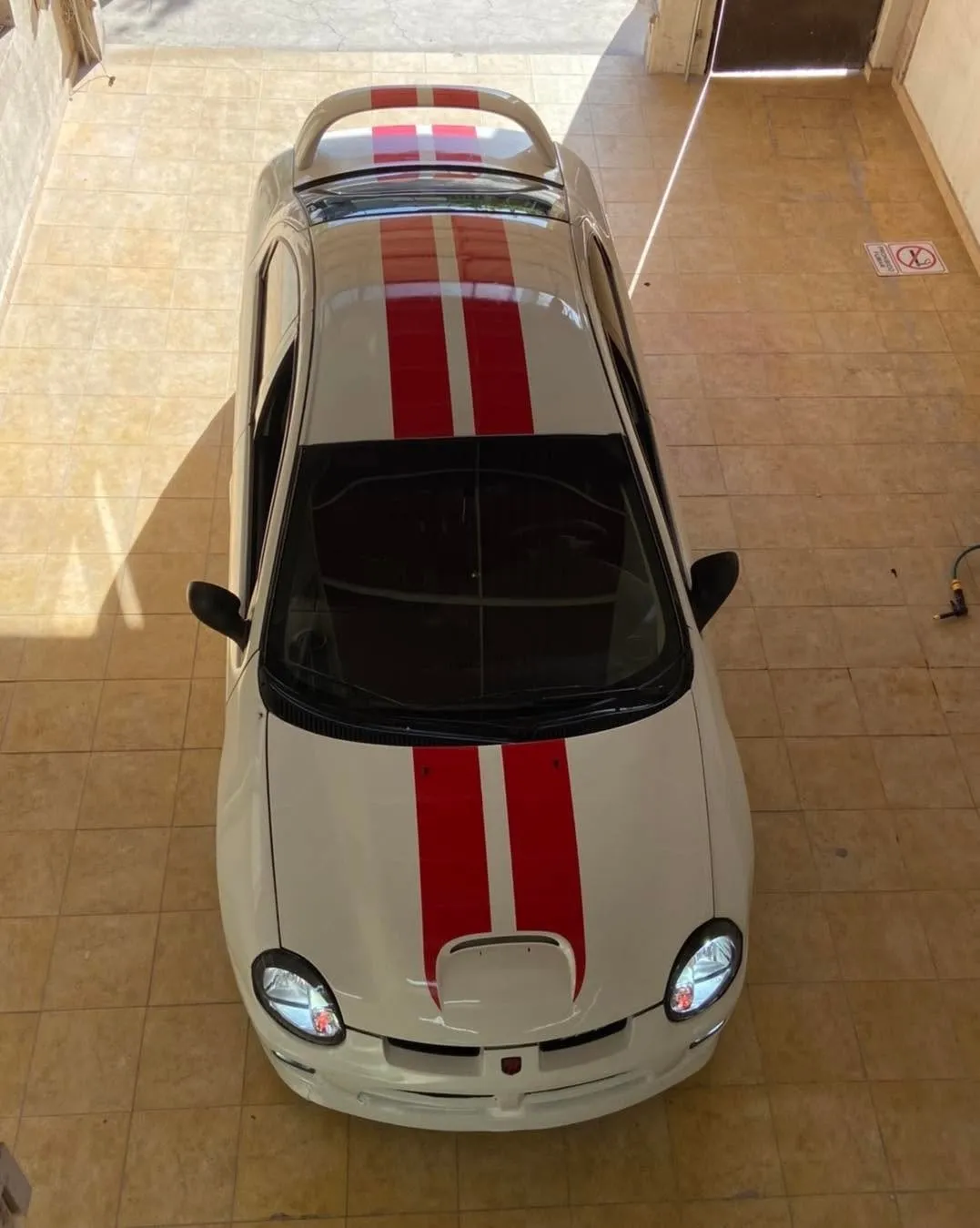 Dodge Neon blanco con franjas rojas, visto desde arriba