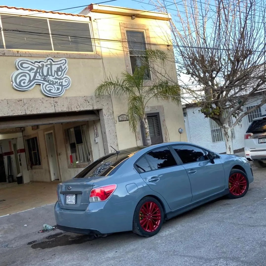Subaru gris con rines rojos frente al segundo taller