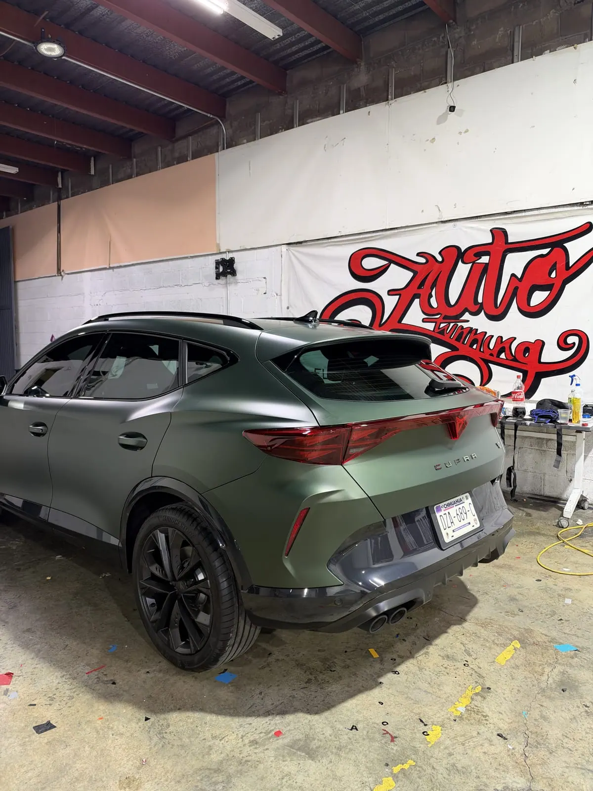 Parte trasera de Cupra Formentor verde con PPF mate, dentro del taller