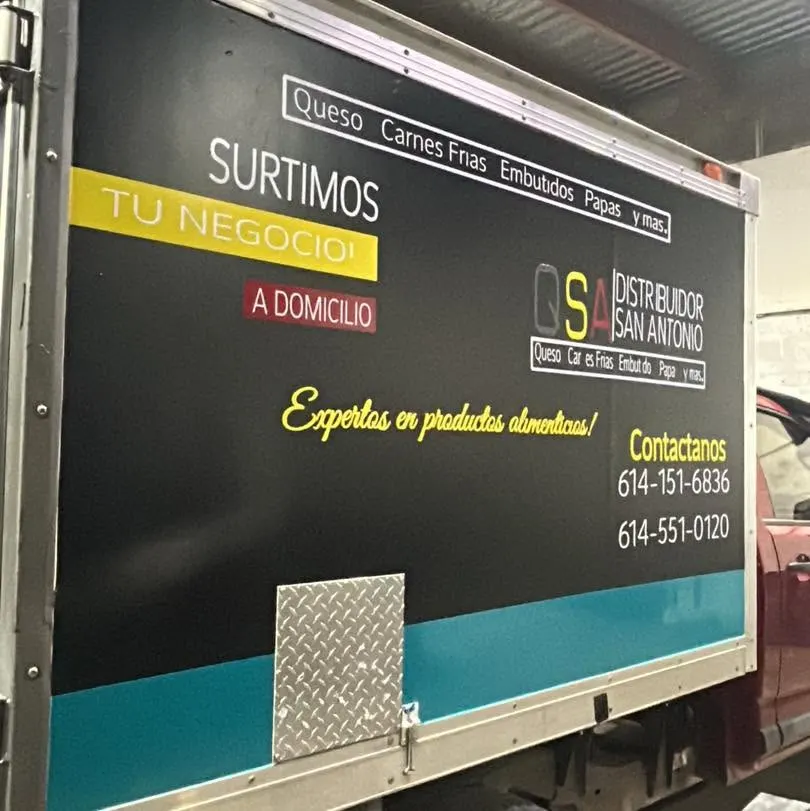 Caja de camión rotulada de un distribuidor de alimentos con servicios y teléfonos
