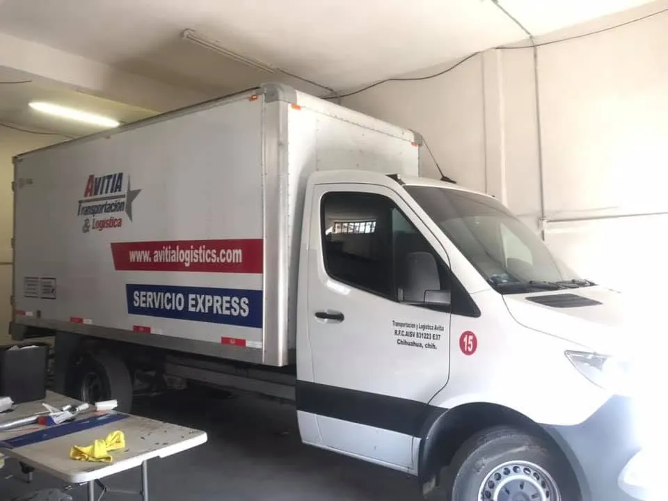 Camión de carga con caja rotulada con logotipo y servicio