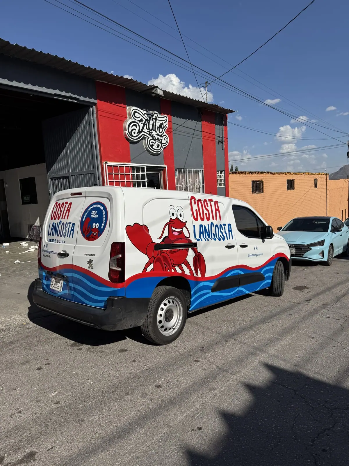Peugeot Partner de Costa Langosta con rotulación de olas y langosta ilustrada
