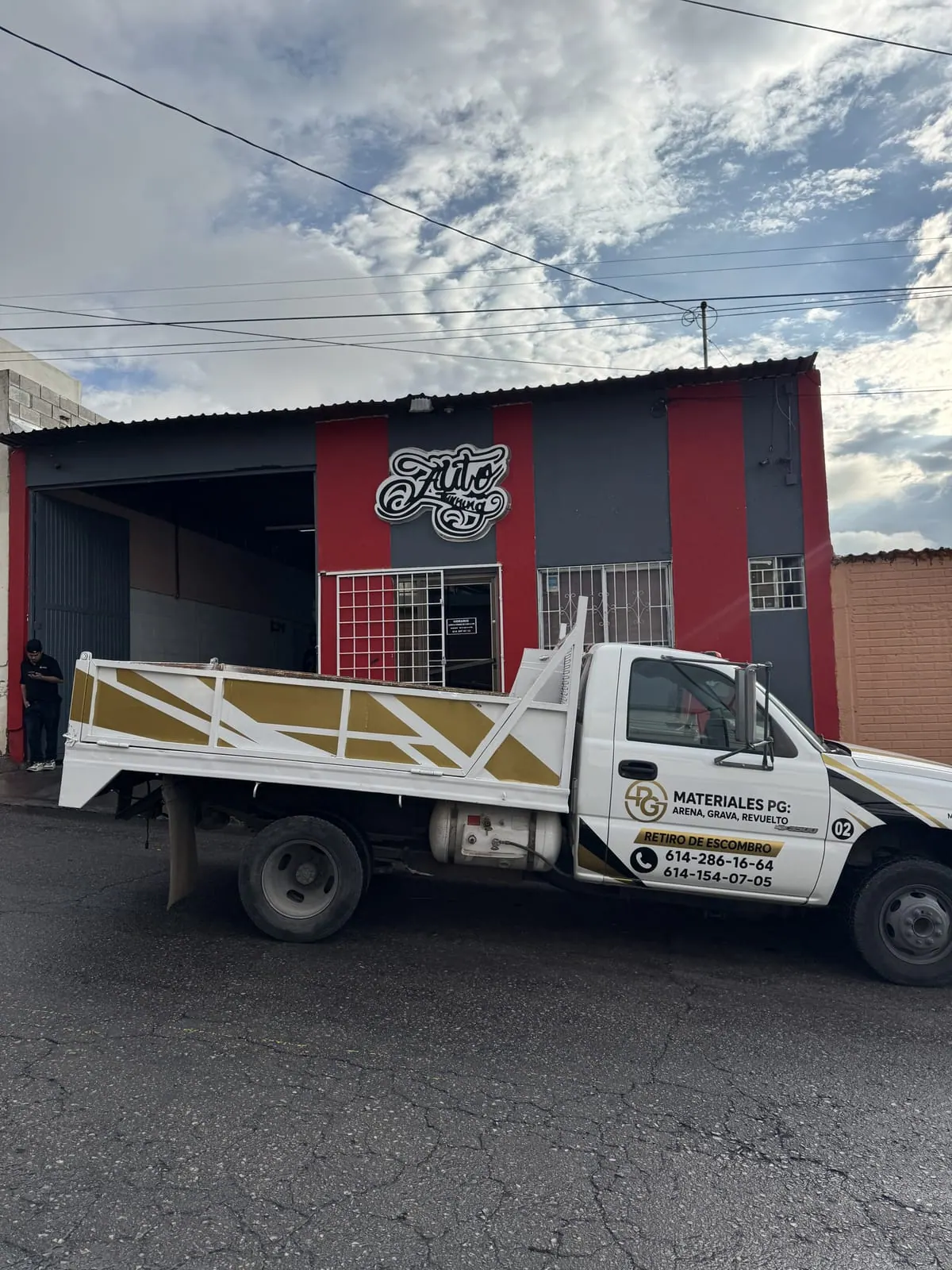 Camión de Materiales PG con gráficos dorados en la caja y rotulación en puertas