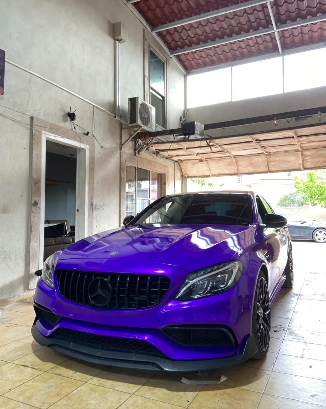 Mercedes-AMG C63 con wrap morado dentro del taller