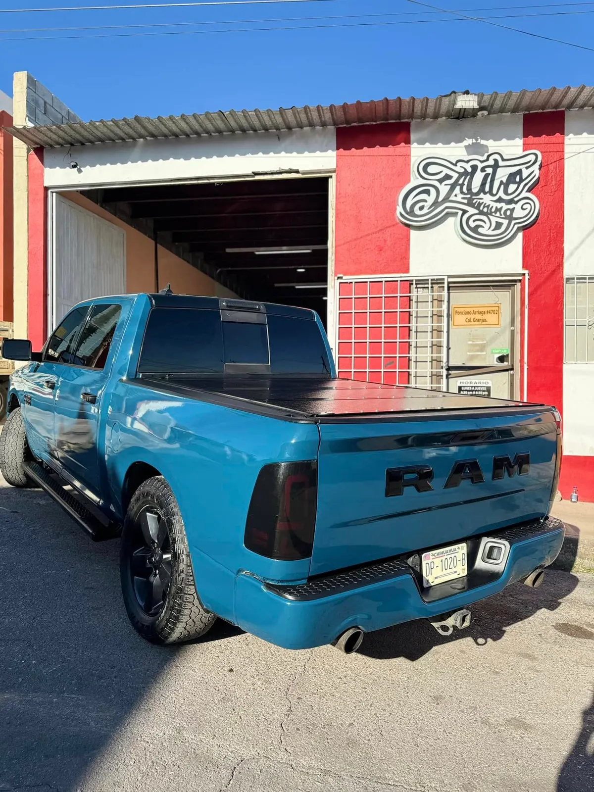 RAM 1500 con wrap azul frente al taller