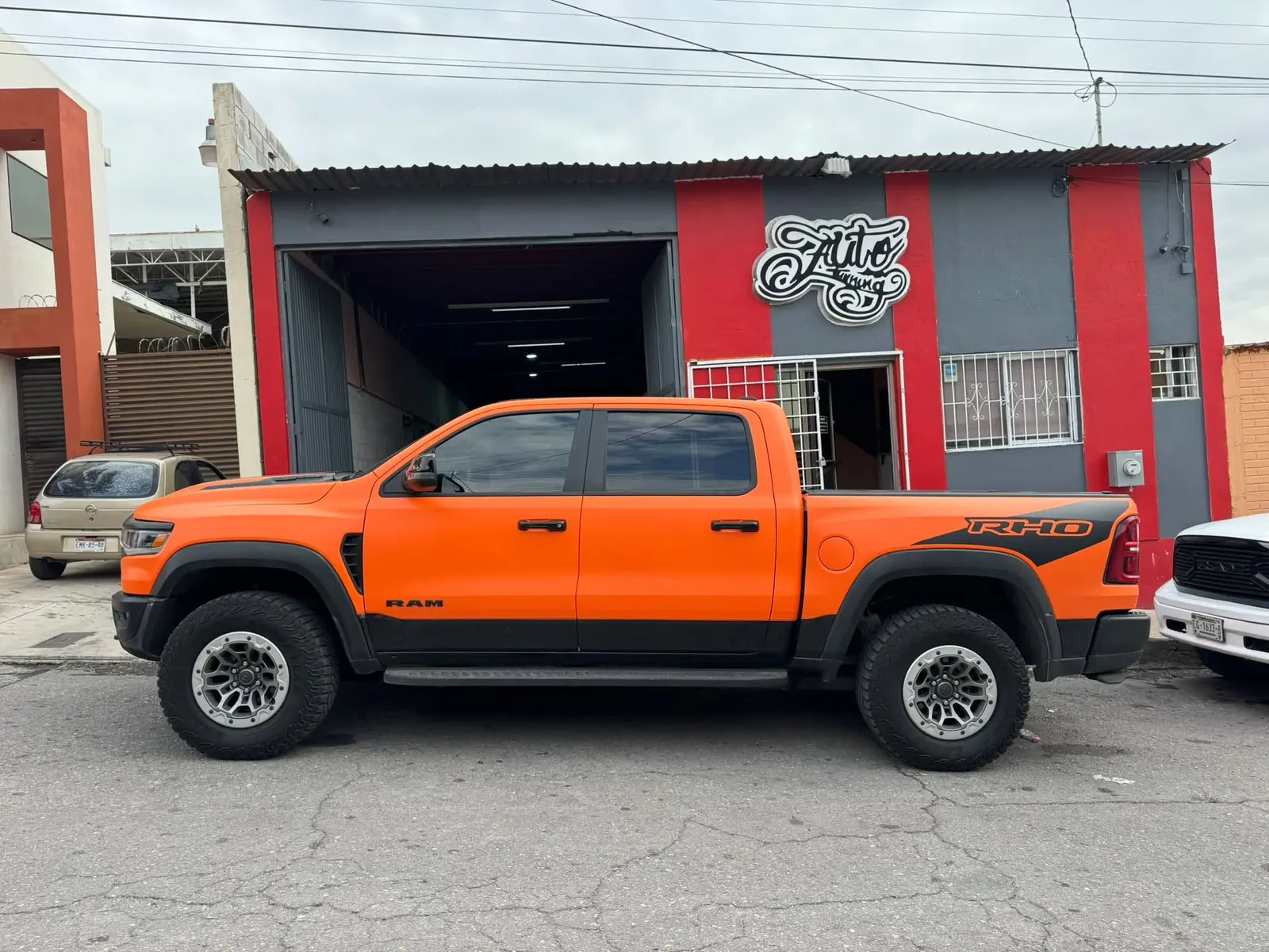 RAM TRX con wrap naranja frente al taller