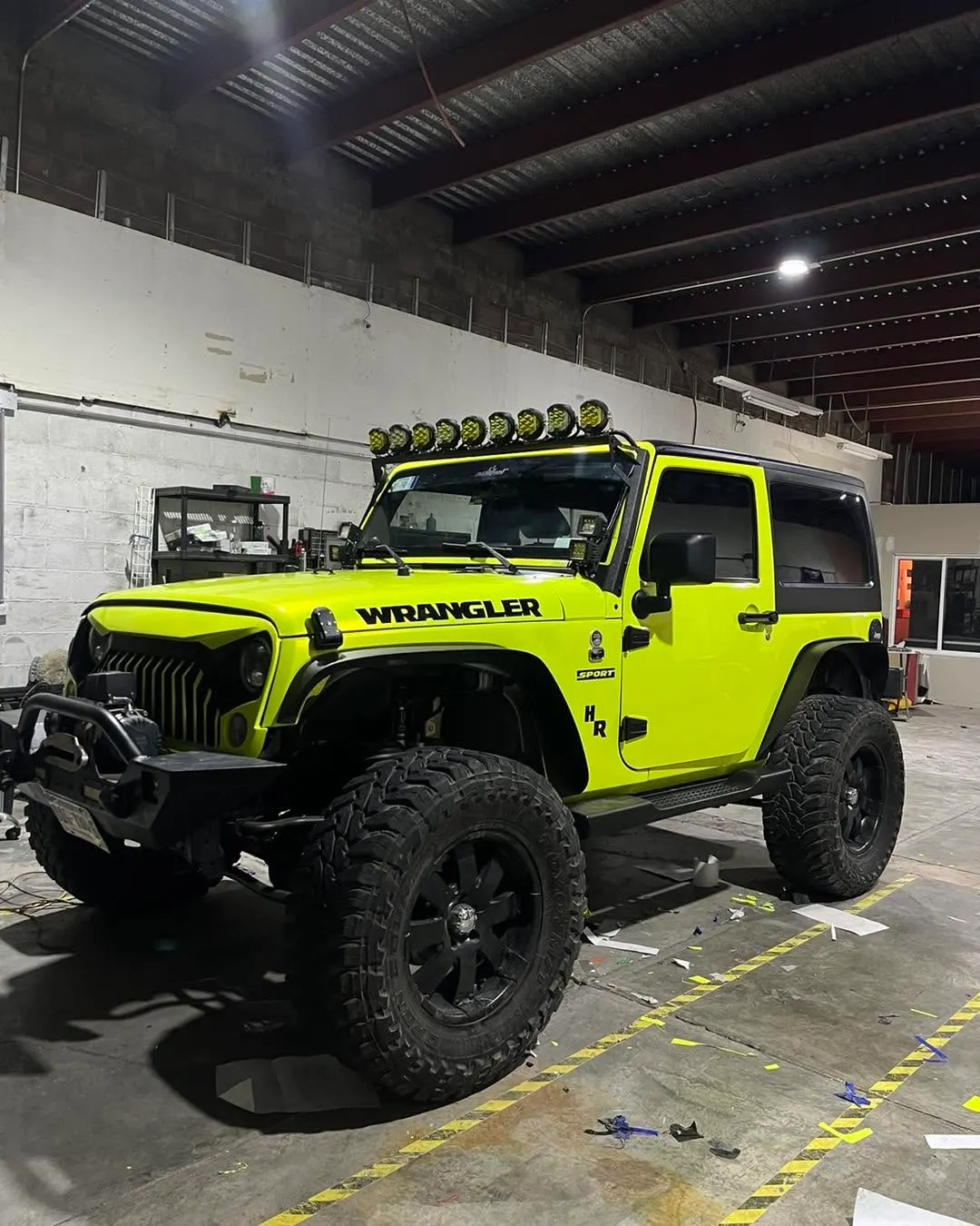 Jeep Wrangler con wrap verde lima dentro del taller